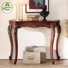 a wooden table with a suitcase on top of it next to a painting and lamp