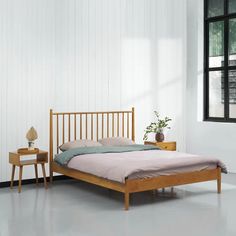 a wooden bed frame in a white room