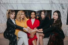 four women sitting on a couch with their hands in each other's lap and one woman holding her hand