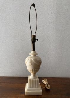 a lamp that is sitting on top of a wooden table next to a cell phone