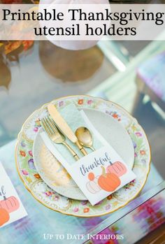 a table set for thanksgiving with place cards and gold utensils on the plate