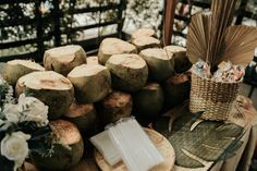 a table topped with lots of cut up coconuts next to flowers and baskets on top of each other