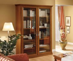 a living room filled with furniture and a book case next to a lamp on top of a table