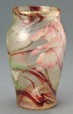 a glass vase with pink flowers painted on the outside and gold trimming around it