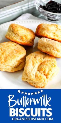 buttermilk biscuits on a white plate with blueberries in the background and text overlay