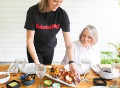 two women are preparing food on a table