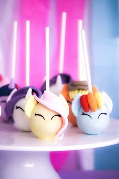 there are many little cake pops with unicorn faces on them