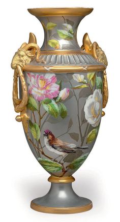 a vase with flowers painted on it and gold trimming around the top, sitting on a pedestal