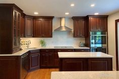 a kitchen with wooden cabinets and marble counter tops