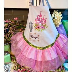 a pink and purple apron with a castle on it sitting on top of a table