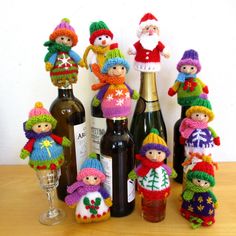 a group of knitted dolls sitting next to wine bottles