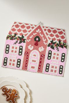 a gingerbread cookie next to an embroidered house