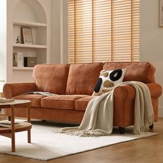 a living room with a couch, chair and coffee table in front of the window