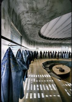 there are many jeans hanging on the clothes line in this room and one is blue