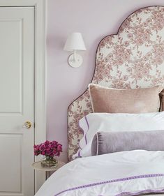 a white bed with pink and purple decor