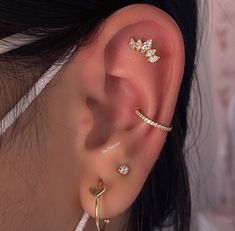 a close up of a person's ear with three different types of piercings