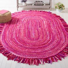 a pink rug is on the floor in front of a shelf and vase with flowers