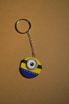 a yellow and blue minion keychain sitting on top of a brown surface