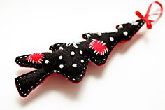 a black and white polka dot christmas tree ornament with red bows on it