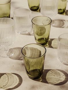 there are many glass cups on the table