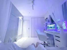 a bedroom with white furniture and purple lights on the ceiling, along with a computer desk