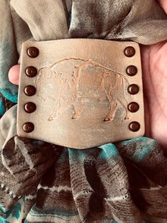 a person holding a belt with a cow on it