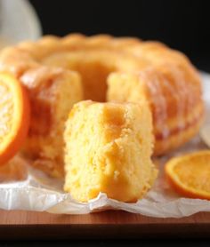 orange bundt cake with orange glaze on a cutting board next to an orange slice