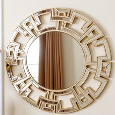 a mirror that is on the wall above a table with a vase in front of it