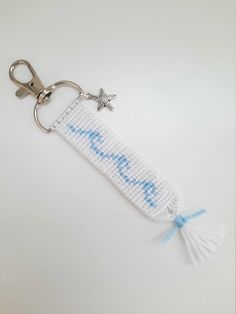 a cross stitch keychain with a starfish on it and the word love is written in blue