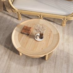 a coffee table with a book on it next to a wicker couch and chair