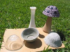 three different types of vases sitting on top of a piece of cardboard in the grass