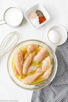 ingredients to make chicken soup laid out on a white counter top, including eggs and seasonings