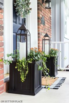 two planters with plants in them on the front porch