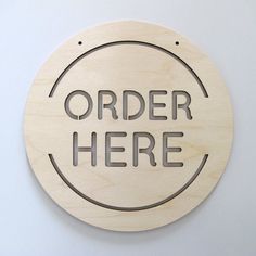 a wooden sign that says order here on it's side, with the words