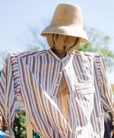 a scarecrow wearing a hat and striped shirt