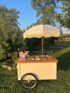 an umbrella is set up on top of a food cart