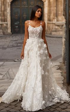 a woman in a wedding dress standing on the street