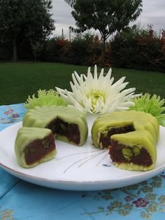 a plate that has some kind of cake on it with flowers in the back ground