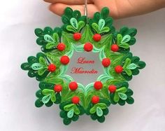 a green ornament with red berries and leaves