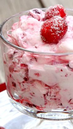 a bowl filled with ice cream and strawberries on top of a white table cloth