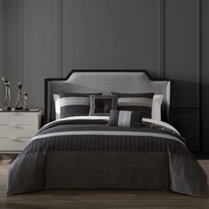 a bed with black and grey comforters in a room