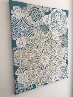 a painting with white lace on it hanging on the wall