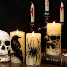 halloween candles with skulls and spiderweaves on them, sitting next to an old book