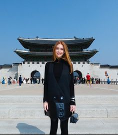 a woman standing in front of a building