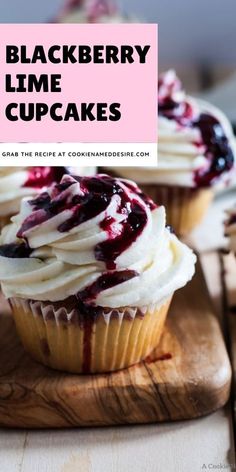 cupcakes with white frosting and blueberry topping on a wooden cutting board