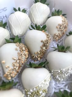 white chocolate covered strawberries in a box with gold trimmings and leaves on top