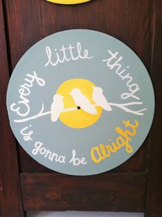 a clock with two birds on it and the words happy little thing is going to be alright