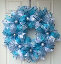 a blue and white wreath hanging on the front door