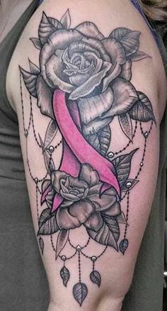 a woman's arm with a pink ribbon and rose tattoo on the left shoulder