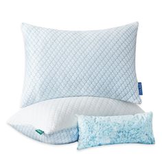 two pillows and one pillow are sitting next to each other on a white surface with blue accents